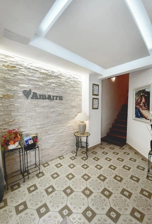 Vhodna veža z belo kamnito steno, napisom Amarru in stopniščem